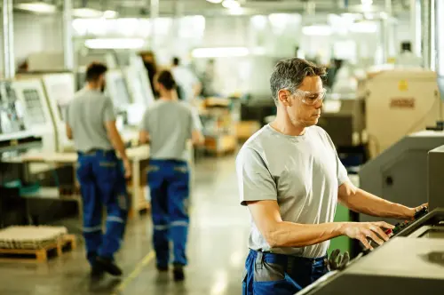 Worker operating a machine on a production floor